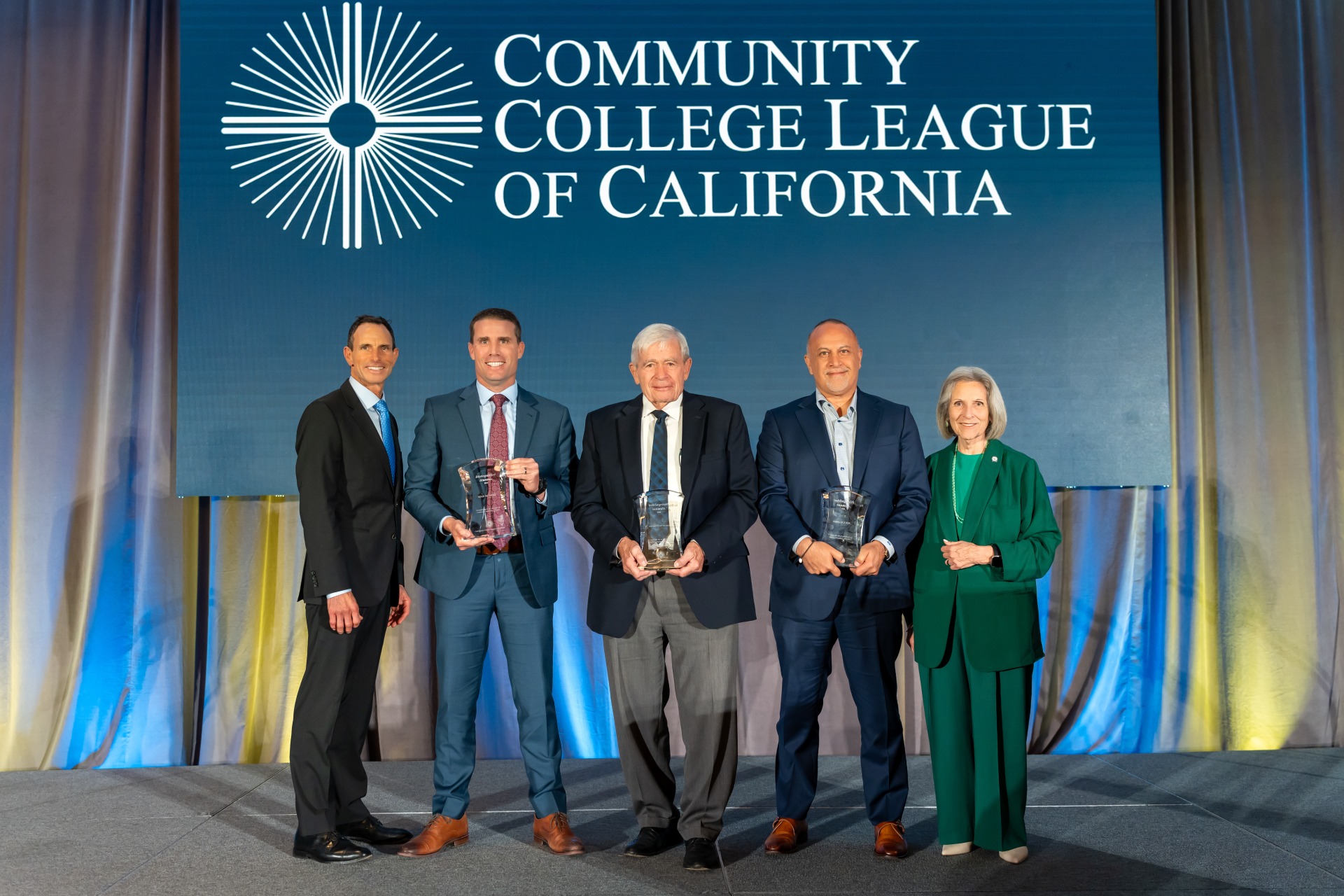President and CEO of CCLC Larry Galizio and former CCT Board President Nan Gomez-Heitzeberg standing with 2024 Distinguished Alumni Award winners Mike McGuire, Marlin "Skip" Davies, Mike Madrid.